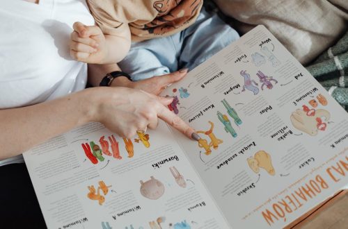 A comforting moment of a mother reading a colorful picture book with her child.